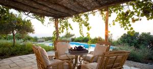 a patio with chairs and a table and a pool at Aphrodite's Oasis in Pomos