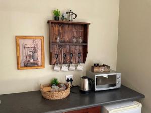 a kitchen counter with a microwave on top of it at Home@Harts in Hartswater