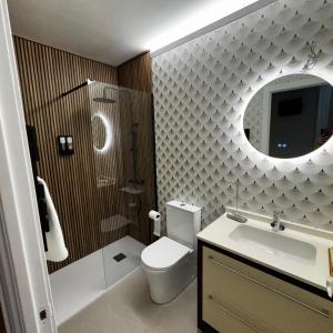 a bathroom with a toilet and a sink and a mirror at Gre2 in El Barco de Ávila