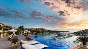 a pool with chairs and a view of a marina at Blu Bay Hotel Sozopol in Sozopol