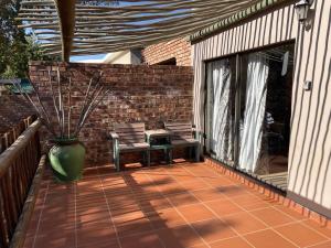 a patio with two chairs and a vase at Home@Harts in Hartswater