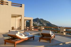 a patio with two lounge chairs and the ocean at Villa Ino in Myrties