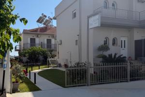 a white house with a fence and a yard at GLEN Premium Stays in Kanali