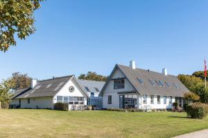 a white house with a gray roof at Rolsø Retreat - the apartment in Knebel
