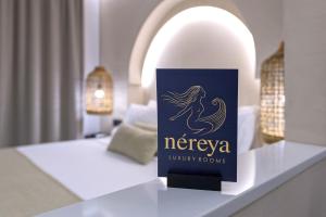 ein Schild, das auf einem Tisch in einem Zimmer steht in der Unterkunft néreya luxury rooms in Charaki