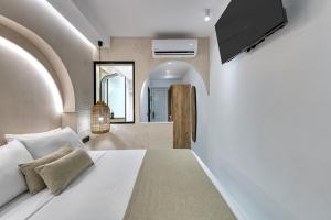 ein Schlafzimmer mit einem Bett und einem Fernseher an der Wand in der Unterkunft néreya luxury rooms in Charaki + 37 Fotos