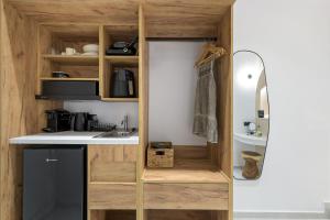 eine kleine Küche mit Holzschränken und einer Spüle in der Unterkunft néreya luxury rooms in Charaki