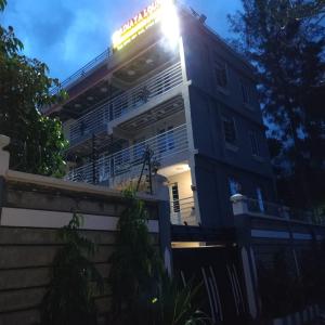 a building with the sun shining on top of it at Rimayalounge in Embu +1 photo