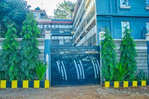 a blue gate with two trees in front of a building at Rimayalounge in Embu