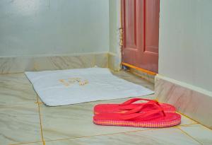a pair of red flip flops on the floor next to a door at Rimayalounge in Embu
