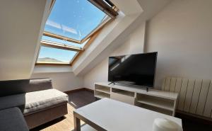 a living room with a couch and a tv at Playa America 4F by YBH in Nigrán