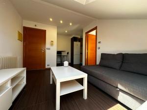 a living room with a couch and a table at Playa America 4F by YBH in Nigrán +1 photo