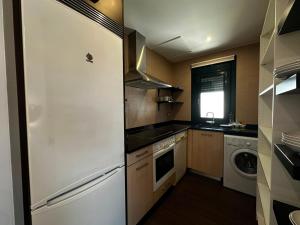 a kitchen with a white refrigerator and a dishwasher at Playa America 4F by YBH in Nigrán