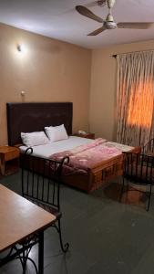 a bedroom with a bed and two chairs and a table at Diamond Hotel Lagos in Lagos