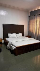 a bedroom with a large bed with white sheets at Diamond Hotel Lagos in Lagos +7 photos