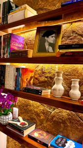 a book shelf filled with books and vases at Chalé Jardim Itália em Tianguá in Tianguá