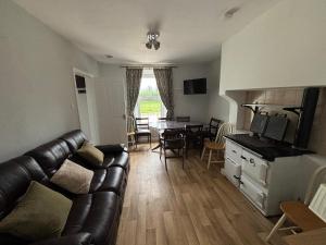 a living room with a couch and a dining room table at Castleroddy House - spacious country house - king beds - extensive parking in Lislap
