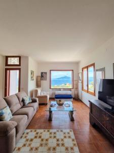a living room with a couch and a tv at Villa Blu Sorrento seaview pool terrace and Jacuzzi in Sorrento