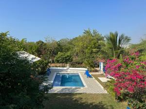 a swimming pool in a yard with pink flowers at Casa de Campo Palmarito in Tubará