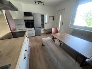 a kitchen with a wooden table and a dining room at Ide Vissza apartman 3 in Siófok