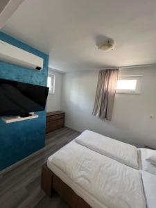 a bedroom with a bed and a flat screen tv at Ide Vissza apartman 3 in Siófok
