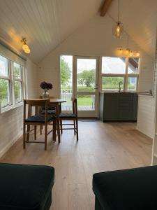 a living room with a table and chairs and windows at Velling Koller Hotel og Camping in Bryrup +36 photos
