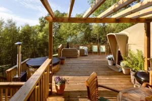 a wooden deck with a table and chairs on it at Hazel Tree Yurt - Eavestone Lake in Grantley