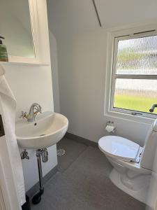 a white bathroom with a sink and a toilet at Velling Koller Hotel og Camping in Bryrup