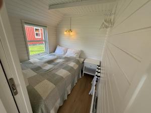 a small bedroom with a bed and a window at Velling Koller Hotel og Camping in Bryrup