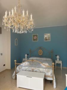 a bedroom with a bed and a chandelier at Villa Ursino in Scalea