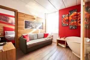 a bathroom with a couch and a tub and a bed at La Filanda Relax&Gourmet in Denno