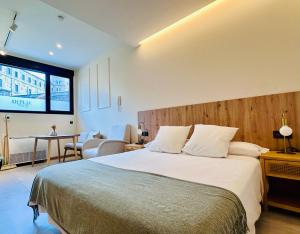 ein Schlafzimmer mit einem großen Bett und einem großen Fenster in der Unterkunft Alpha Estudios, Apartamentos turísticos in Astorga