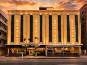 a large building with lights on top of it at Smart Gate Hotel Apartments سمارت غيت للشقق الفندقية in Jazan
