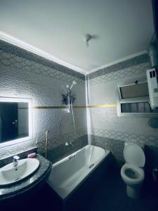 a bathroom with a tub and a sink and a toilet at الشرقيه in Kafr al Ishārah