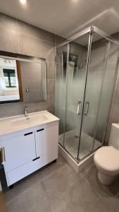 a bathroom with a shower and a sink and a toilet at Playa America 1E by YBH in Nigrán +4 photos