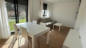 a living room with a white table and chairs at Playa America 1E by YBH in Nigrán