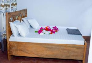 a bed with flowers sitting on top of it at Ecokayak Beach Lodge in Zanzibar City