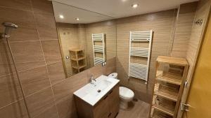 a bathroom with a sink and a toilet and a mirror at Playa America 1E by YBH in Nigrán