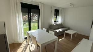 a white living room with a couch and a table at Playa America 1E by YBH in Nigrán