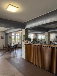 a kitchen and dining room with a bar and tables at Hotel Turist Beharca in Beharca