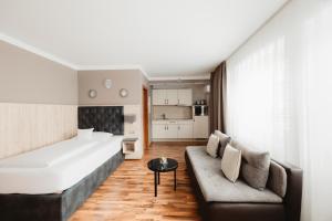 a bedroom with a large bed and a couch at ART Hotel Grenzach-Wyhlen bei Basel in Grenzach-Wyhlen