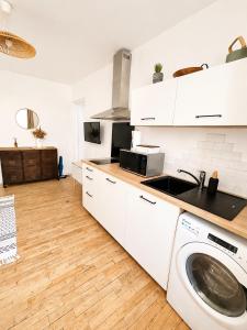 a white kitchen with a washing machine in it at Le Byzantin - T2 Hyper centre in Pontivy +13 photos