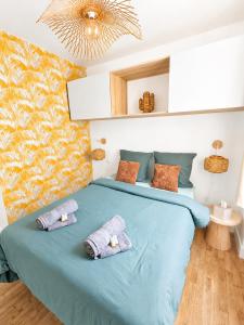 a bedroom with a blue bed with two pillows on it at Le Byzantin - T2 Hyper centre in Pontivy