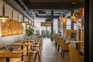 a restaurant with wooden tables and chairs and lights at Hotel Delfín 4 Sup in Tossa de Mar