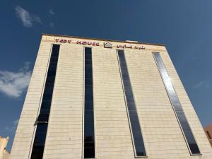 a tall building with a sign on the top of it at منازل التوت للشقق المخدومة القيم in Taif