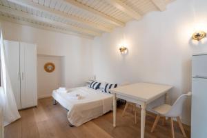 ein weißes Zimmer mit einem Bett und einem Tisch in der Unterkunft Breva e Tivano in Rezzonico
