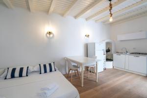 ein Schlafzimmer mit Bett und Tisch und eine Küche in der Unterkunft Breva e Tivano in Rezzonico