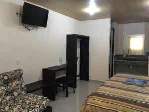 a bedroom with a bed and a desk and a chair at 8 Hotel Ejecutivo in Jocotitlán