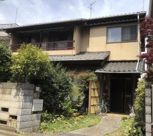 a house with a bike parked in front of it at スペースigusa専用寝室2室に2名様3泊よりマンスリー割引がおすすめ in Tokyo