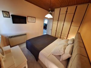 a bedroom with a bed and a couch and a tv at Casa di TSANES in Pinakokhórion